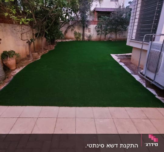 דשא סינתטי בגינה עם עצים מסביב